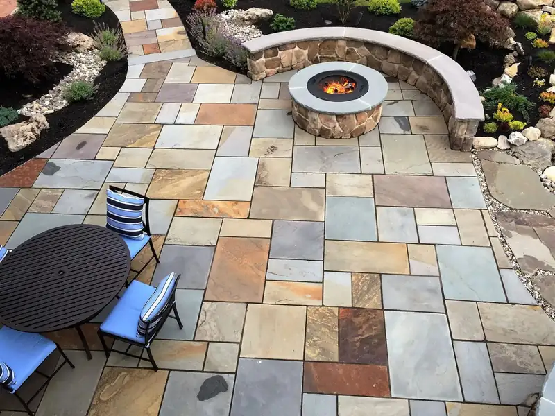 Natural stone paver patio with a built-in stone fire pit, seat wall and outdoor dining area